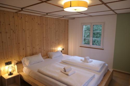 a bedroom with a large bed with two towels on it at theBlackwood in Todtnauberg