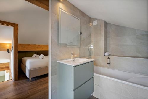 a bathroom with a sink and a shower with a tub at Résidence Freddie in Tignes