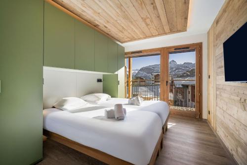 two beds in a room with green walls at Résidence Freddie in Tignes