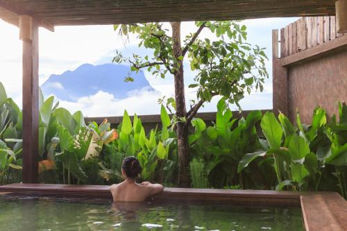 a man in a swimming pool in a garden at Azalea Village in Chiang Dao