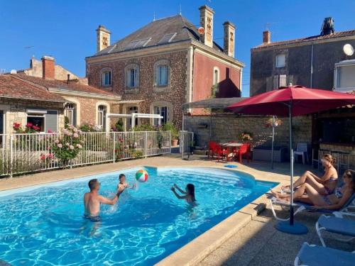 a group of people playing with a ball in a swimming pool at La Villa des Roses Gîte Chambres d'hôtes Piscine chauffée in Luçon