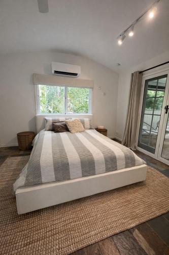 a large bed in a bedroom with a window at Private Rainforest Guesthouse in Doonan in Doonan