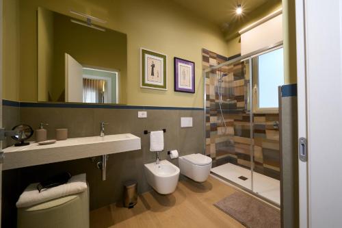 a bathroom with a toilet and a sink and a shower at Merlino Urban Suites in Messina