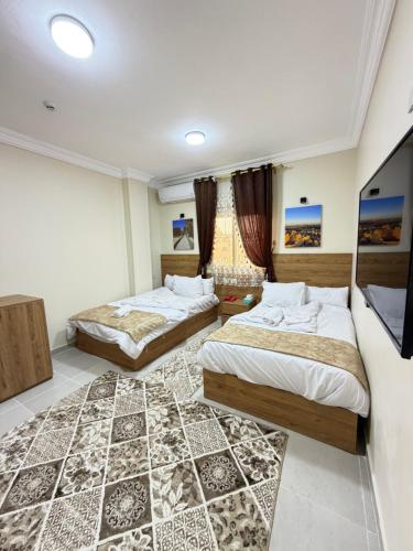 a bedroom with two beds and a rug at Siwa Star Rooms in Siwa