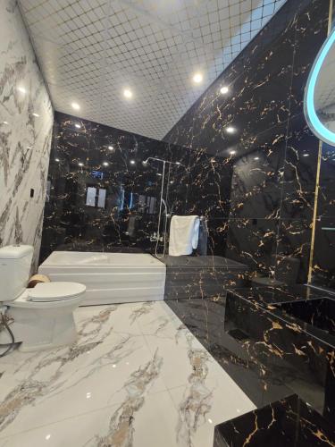 a bathroom with a white toilet and a black wall at Bahria Premium Hotel in Rawalpindi