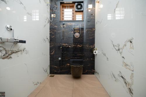 a bathroom with a black door with a toilet at Reunion Ocean Hridayam - Beach House in Udupi