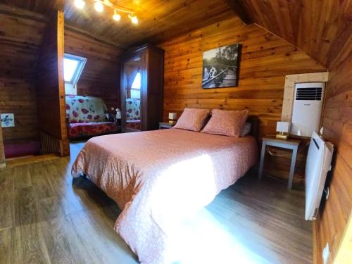 a bedroom with a bed in a wooden cabin at Gite les Courtaillards in Couches