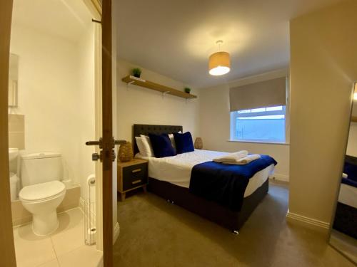 a bedroom with a bed and a toilet in it at Wokingham Stylish Two Bedroom Apartment in Wokingham