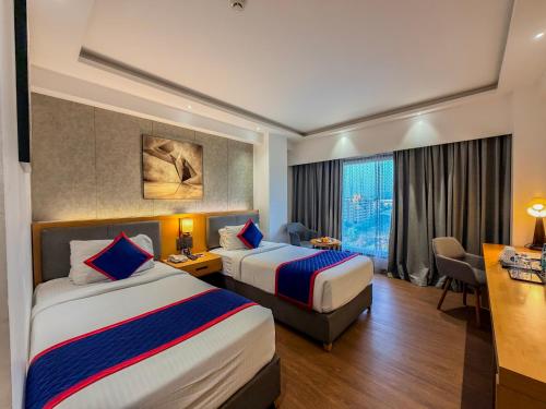 a hotel room with two beds and a window at Zip By Spree Hotels Chakan, Pune in Pune