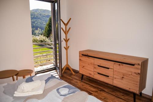 a bedroom with a bed and a dresser and a window at Chata Zingoty in Mýto pod Ďumbierom