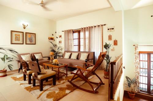a living room with a couch and a table at Bougain Blossom Spacez Luxury Villa with Terrace Garden in Bangalore