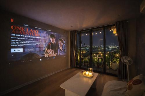 a living room with a large movie poster on the wall at AimeeHouse - Trích Sài in Hanoi