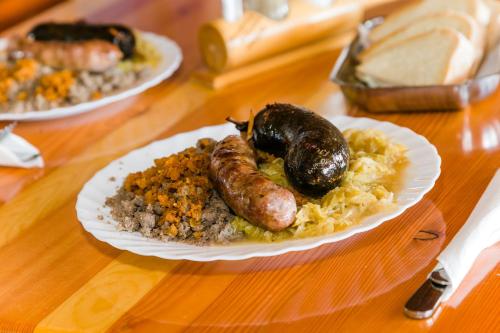 un piatto di cibo con salsicce e riso su un tavolo di EkoTurizem Viženčar a Cerklje na Gorenjskem