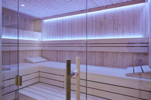 a sauna with wooden paneling and a glass wall at Bernstein Suite & Breakfast Apartment 05 in Büsum