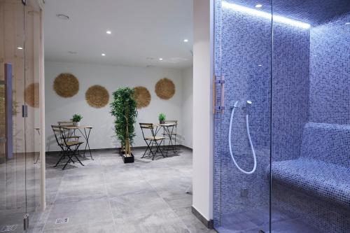 a bathroom with a shower and tables and chairs at Bernstein Suite & Breakfast Apartment 05 in Büsum