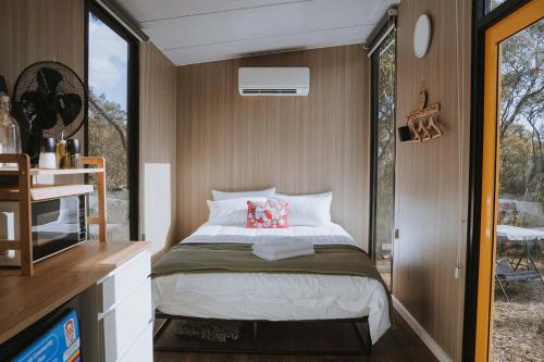 a small bedroom with a bed and a window at Pigeon Pair Tiny Houses by Tiny Away in Tallarook
