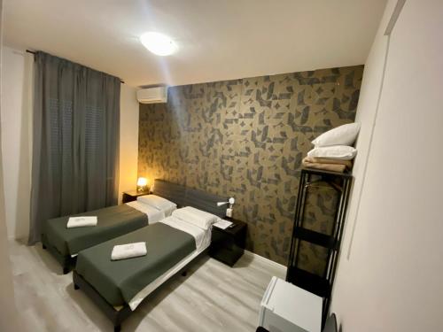 a small room with two beds and a shelf at Guest House Pirelli Milano in Milan