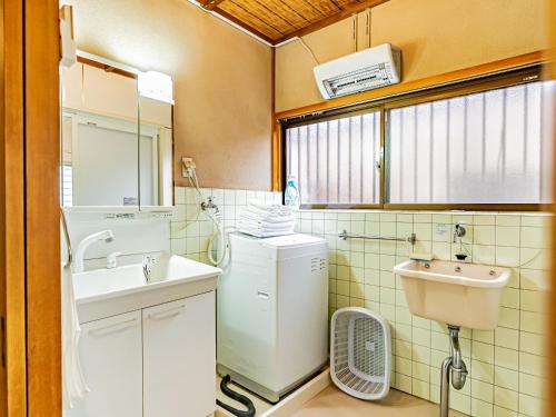 a bathroom with a sink and a washing machine at The M HONMACHI in Nakatsugawa