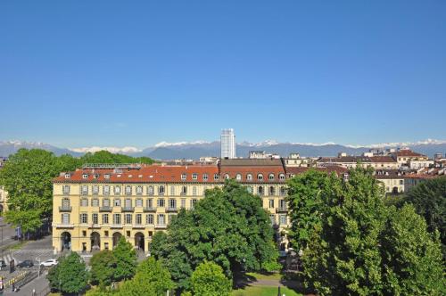 a large building with trees in front of it at Hotel Roma e Rocca Cavour in Turin