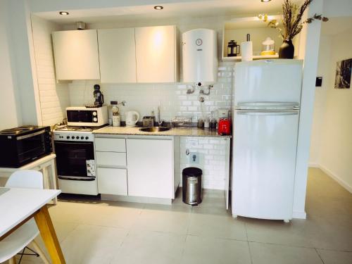 a kitchen with white cabinets and a white refrigerator at Depto H in Buenos Aires