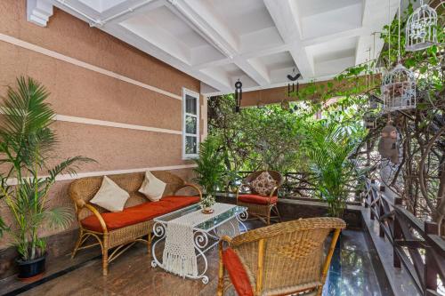 a balcony with wicker furniture and plants at Bougain Blossom Spacez Luxury Villa with Terrace Garden in Bangalore
