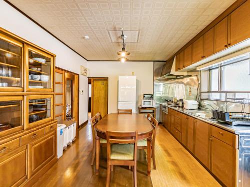 a large kitchen with a wooden table and chairs at The M HONMACHI in Nakatsugawa