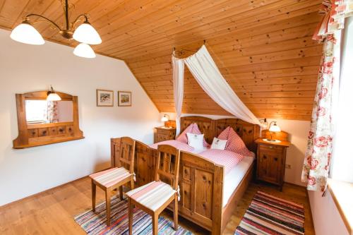 a bedroom in a log cabin with a bed and two chairs at Haunzwickl Ferienhaus in Mürzzuschlag