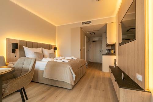 a hotel room with a bed and a chair at Your Holidays Infinity A233 in Międzyzdroje