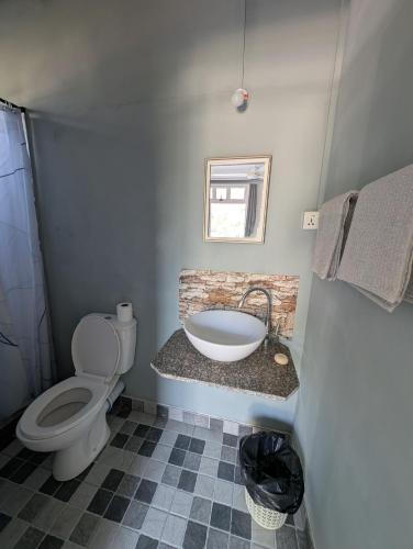a bathroom with a white toilet and a sink at Desirella Villa studio in Mahébourg