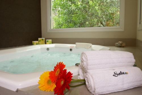 La salle de bains est pourvue d'une baignoire, de serviettes et d'une fenêtre. dans l'établissement Gala Apart Boutique & Spa -Sólo para Adultos-, à Mar de las Pampas