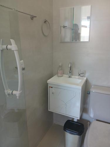 a bathroom with a toilet and a sink and a shower at Kitinete encantadora in Arraial do Cabo