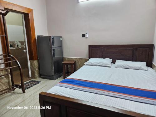 a bedroom with a large bed and a refrigerator at AJk villa in Negombo