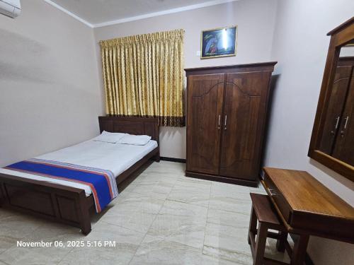 a bedroom with a bed and a cabinet and a desk at AJk villa in Negombo