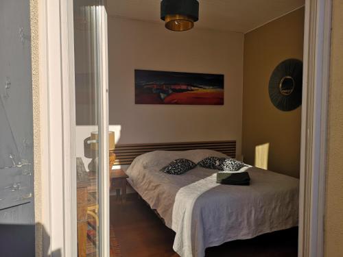 a bedroom with a bed with two pillows on it at Villa la Roseraie chambre avec sdb privée in Montpellier