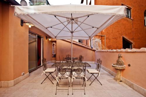 a table and chairs with an umbrella on a patio at LM Suites Spagna in Rome