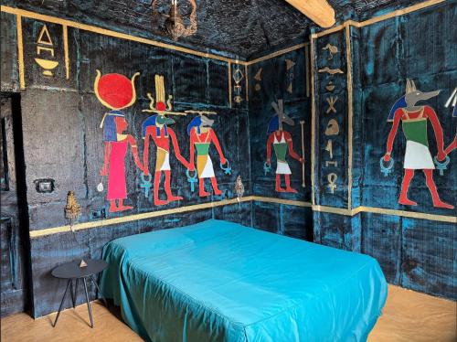 ein Zimmer mit einem Bett mit Gemälden an der Wand in der Unterkunft Paciu Maison - Dimora Artistica Immersiva in Ozzano dell’Emilia