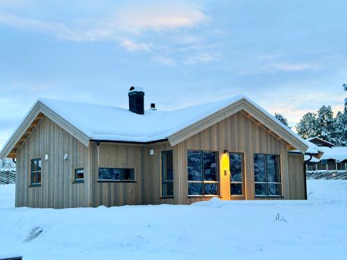 a house with snow on top of it at Måsåplassen Friisvegen Mountain Lodge in Ringebu