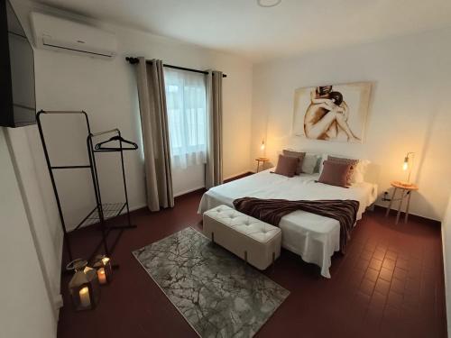 a bedroom with a large bed and a woman on the wall at H2Furnas Natur in Furnas
