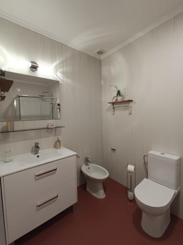 a white bathroom with a toilet and a sink at H2Furnas Natur in Furnas