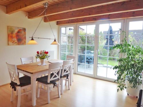 a dining room with a wooden table and chairs at Rosenhaus in Kappeln