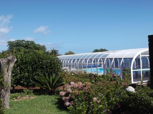 a garden with a greenhouse and some plants and flowers at Quinta da Abegoaria in Abegoaria