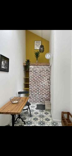 a room with a table and a brick wall at Marée Ault - Maison de ville échappée mer in Ault