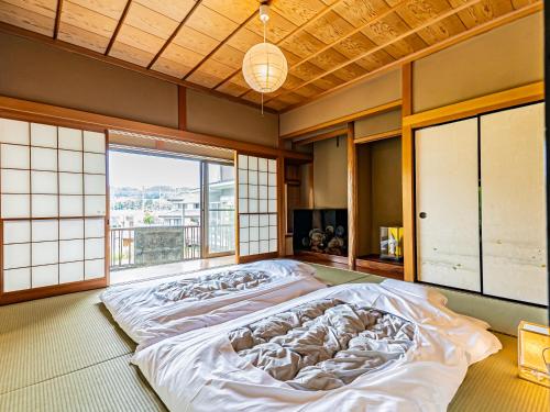 a large bed in a room with a large window at The M HONMACHI in Nakatsugawa
