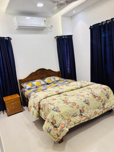 a bedroom with a bed with blue curtains and a heater at Love shore in Cochin