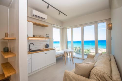 a living room with a couch and a kitchen with ocean views at Elia Suites in Falasarna