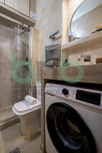 a washing machine in a bathroom with a toilet at Markella Lux Apartment in Alexandroupoli