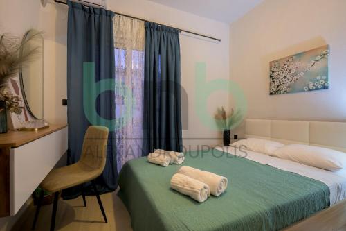 a bedroom with a bed with two towels on it at Markella Lux Apartment in Alexandroupoli