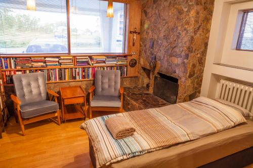レイキャビクにあるCozy 60's villa in Reykjavikのベッドルーム1室(ベッド1台、椅子2脚、暖炉付)