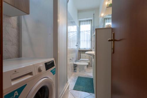 a bathroom with a washing machine and a toilet at Bicocca Urban Suite - SELF CHECKIN WIFI in Novara