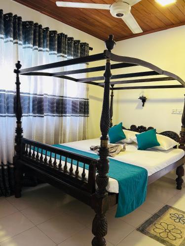 a bedroom with a four poster bed in a room at VILLA No34 HIKKADUWA in Hikkaduwa